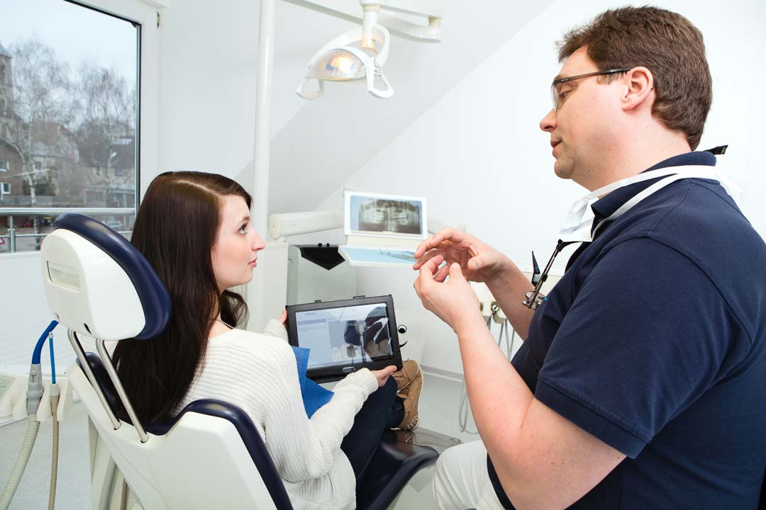 Dr. Anders berät eine Patientin mit Hilfe eines Zahn-Modells